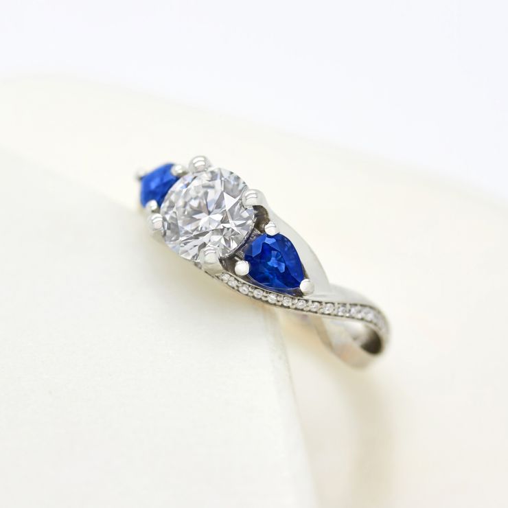 Trilogy ring with sapphire side stones
