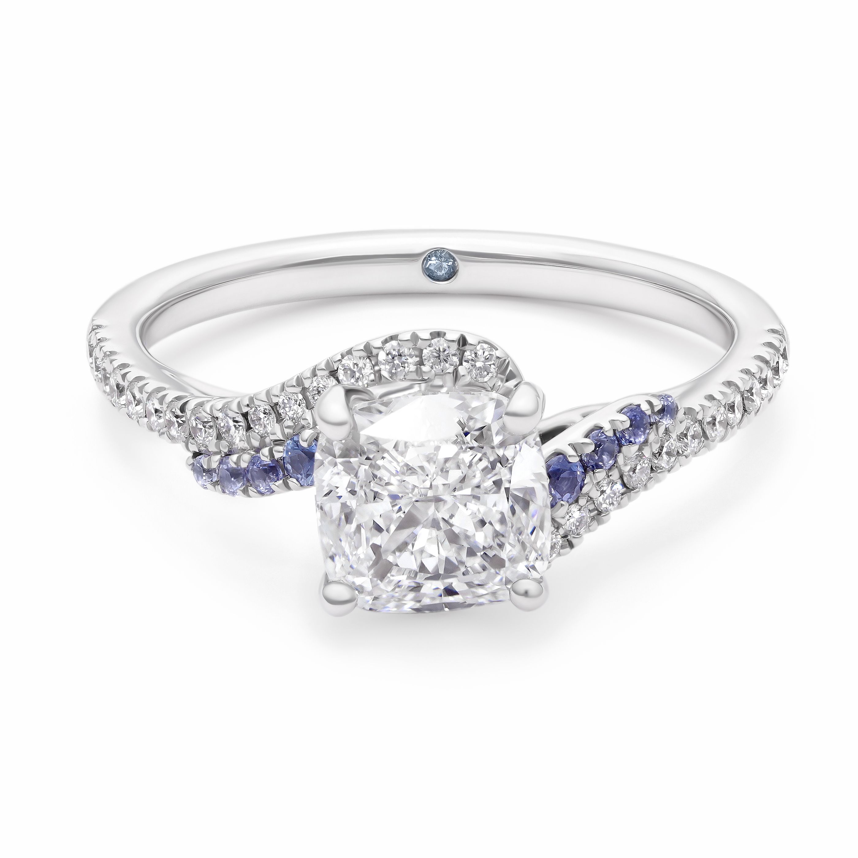 Custom platinum engagement ring with cushion cut diamond centre and asymmetric air current flows swirls in blue sapphire and diamond pave band and basket filigree copy