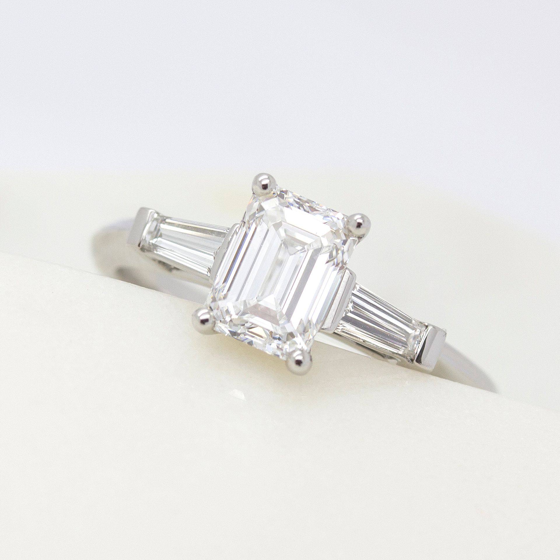 Emerald cut diamond trilogy engagement ring with tapered baguette accent stones