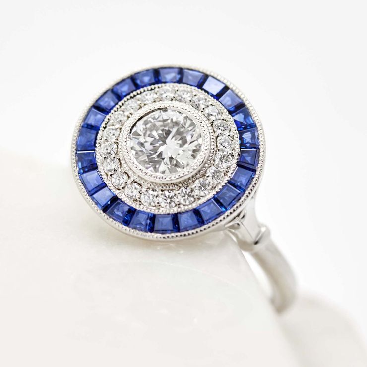 Round diamond with a blue sapphire halo set in platinum