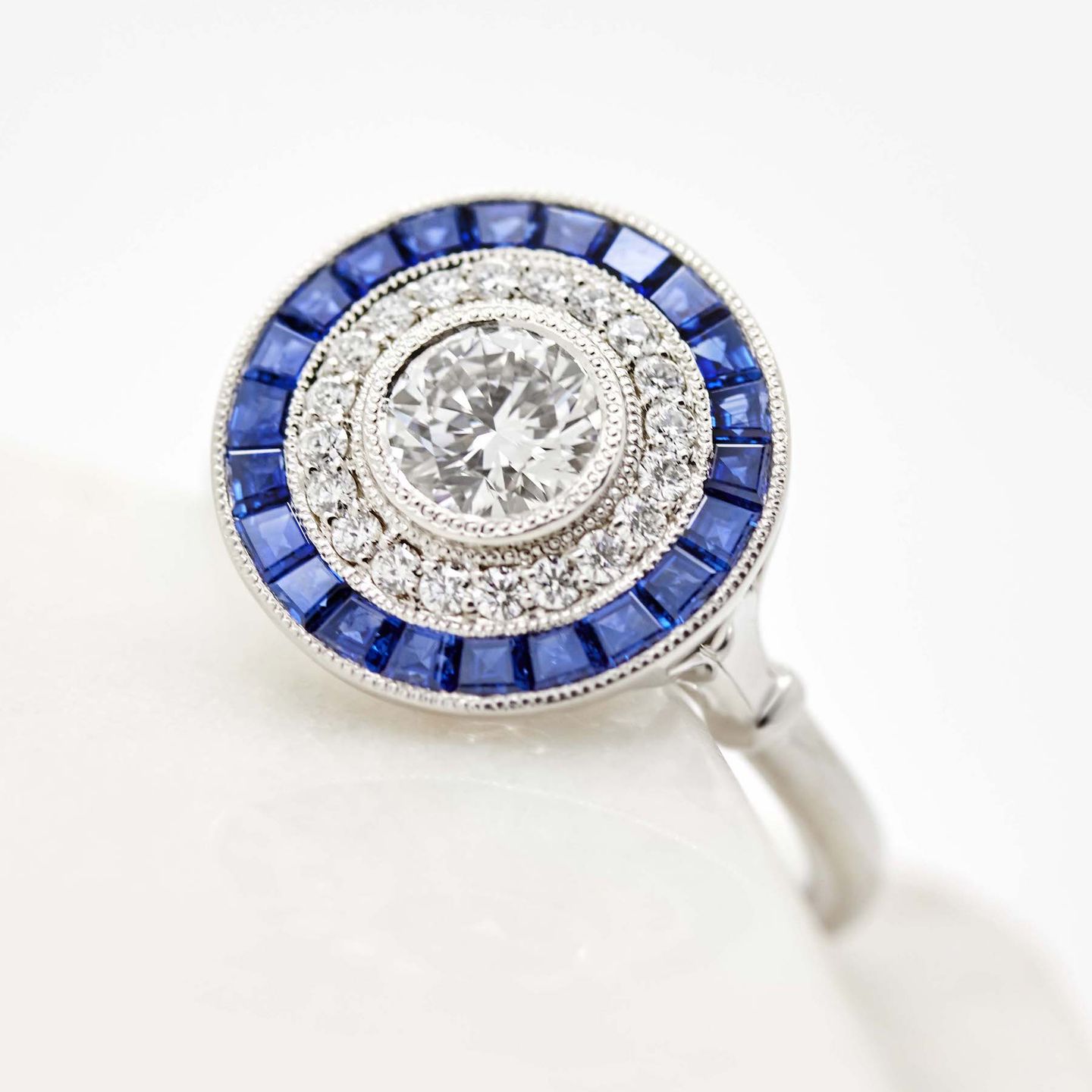 Round diamond with a blue sapphire halo set in platinum