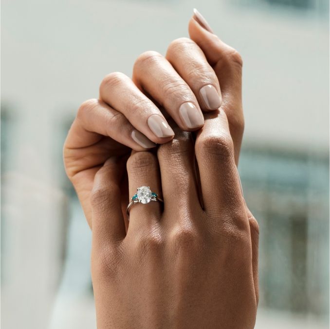 Faith trilogy engagement ring oval diamond teal pear side sapphires on hand