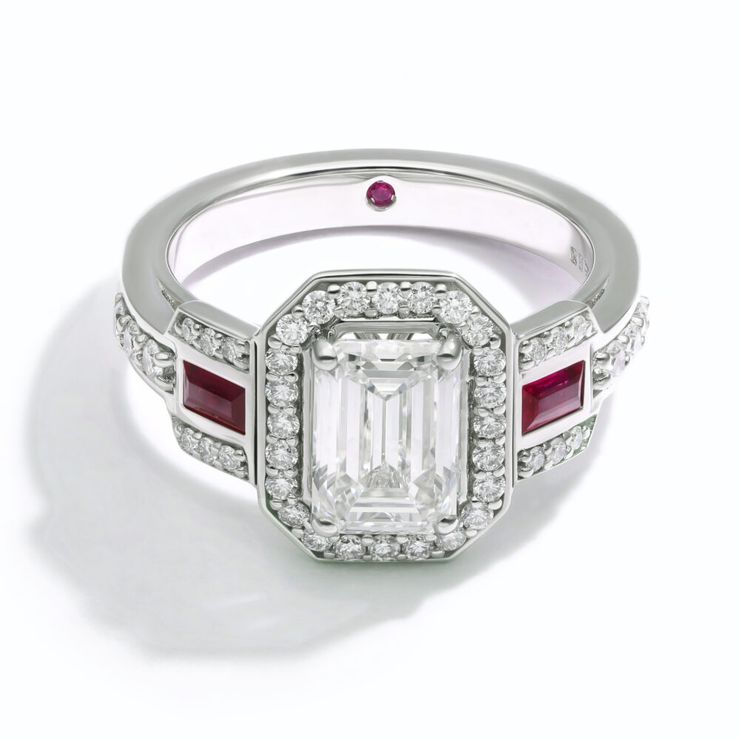 Emerald diamond halo engagement ring with belt-style pavé and baguette rubies