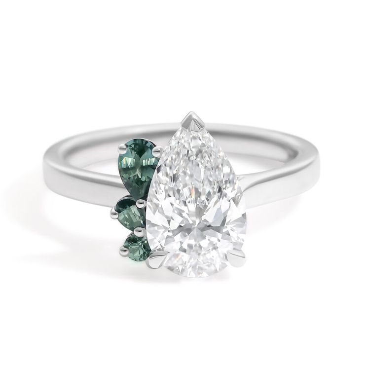 Pear diamond platinum engagement ring with teal green pear clustered accent stones