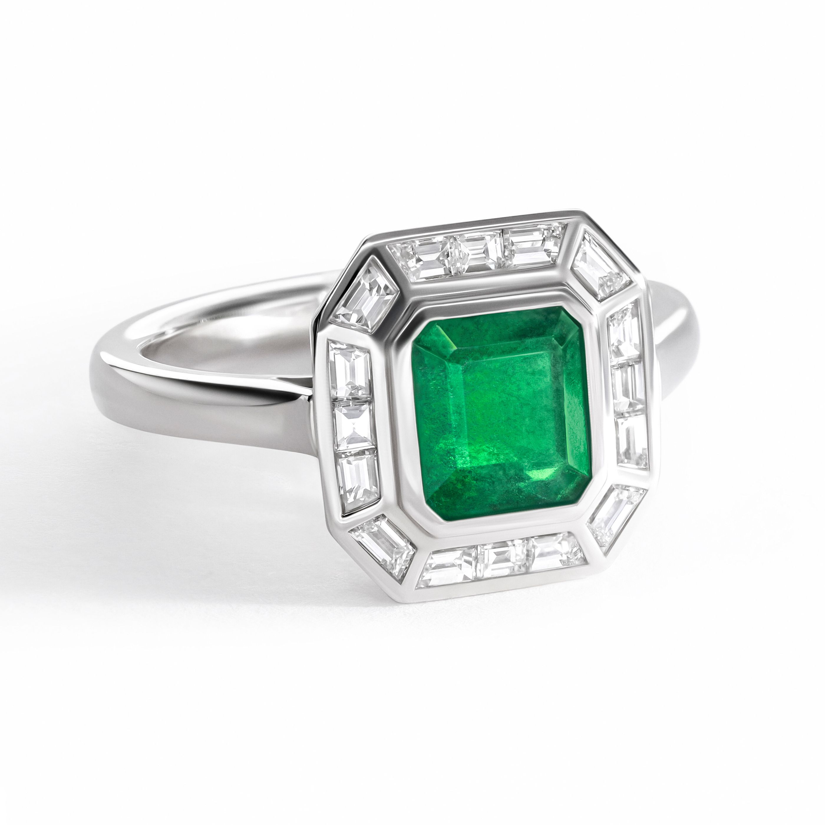 Emerald cut emerald set in platinum with a baguette halo