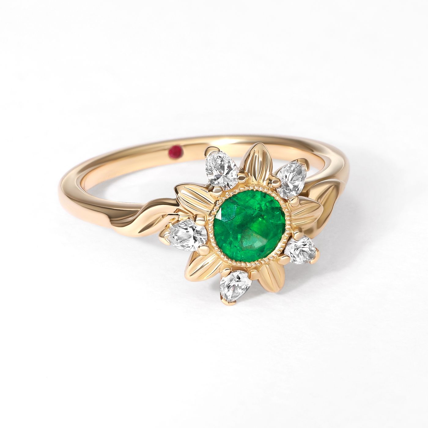 Round emerald bezel set in a yellow gold floral halo