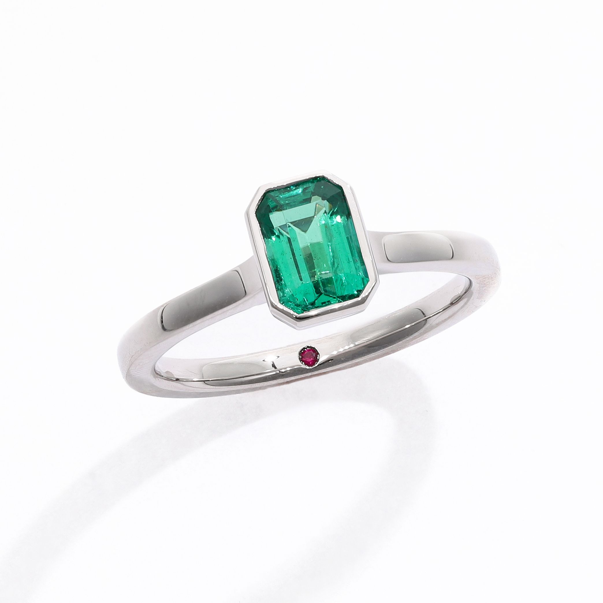 Emerald cut emerald bezel set platinum engagement ring