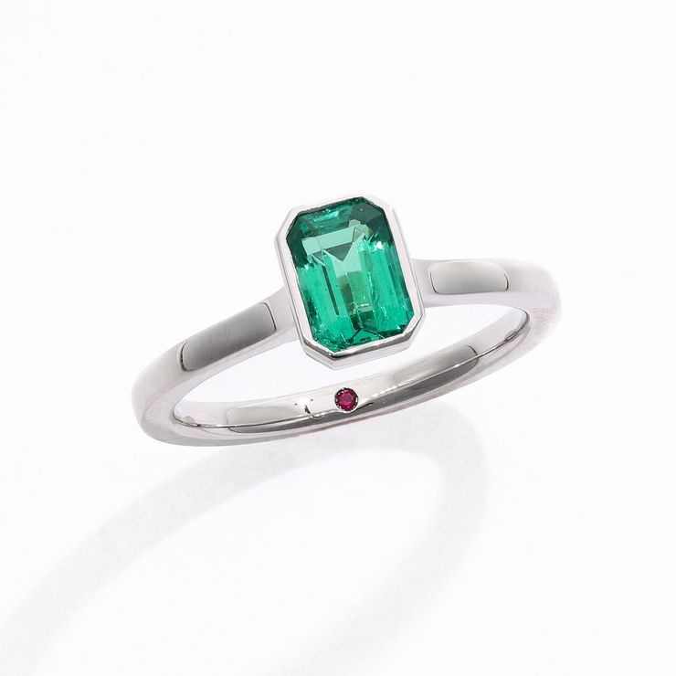 Emerald cut emerald bezel set platinum engagement ring