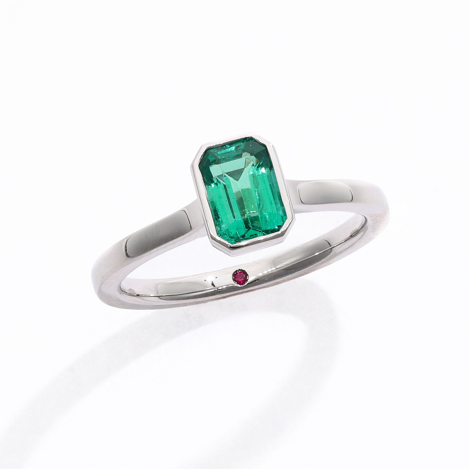 Emerald cut emerald bezel set platinum engagement ring