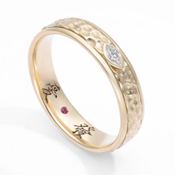 Custom yellow gold wedding ring with hammered finish and marquise east-west set diamond