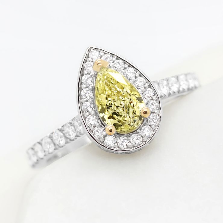 Pear yellow diamond with yellow gold claws and platinum diamond halo engagement ring