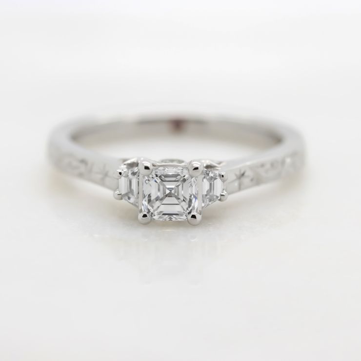 Asscher cut diamond set in a platinum band with engraving