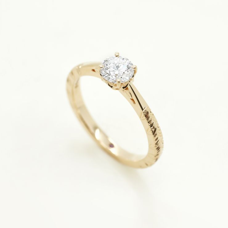 Round brilliant diamond set in yellow gold with engraving