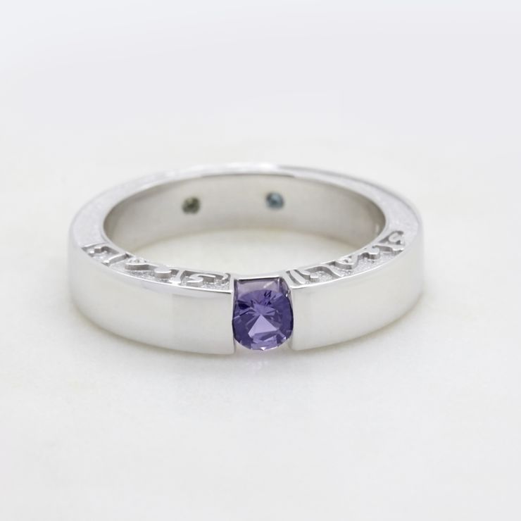 Round purple sapphire tension set in platinum with an engraving