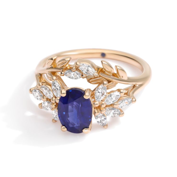 Organic laurel inspired yellow gold engagement ring with oval blue sapphire and marquise diamond accents
