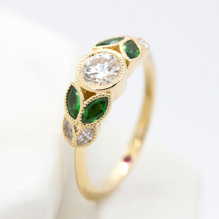 Bezel set round diamond with marquise emerald and diamonds set in yellow gold organic inspired engagement ring