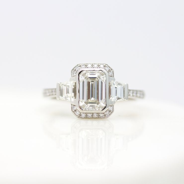 Emerald cut diamond with north-south halo and accent trapezoids