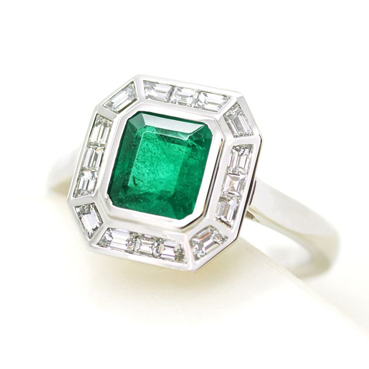 Emerald cut emerald with custom cut diamond baguette halo engagement ring