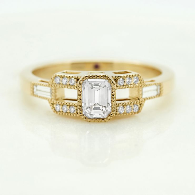 Art deco inspired emerald cut diamond with milgrain engagement ring