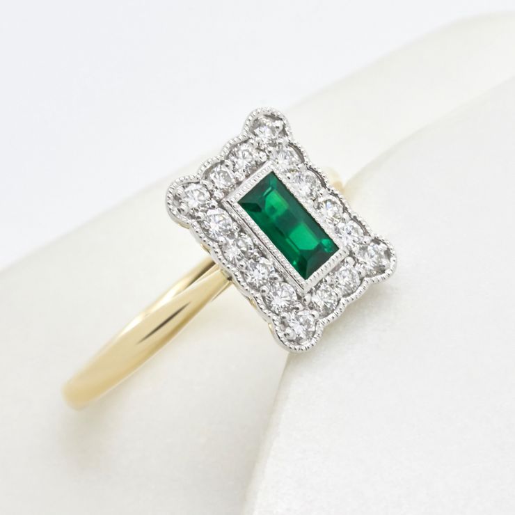 Emerald cut emerald and a round diamond halo with milgrain