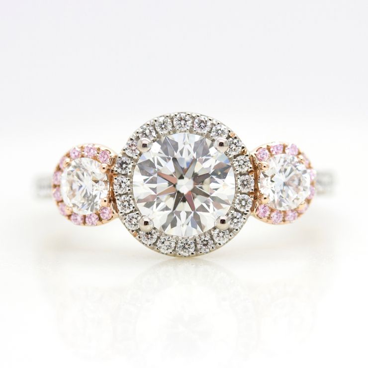 Round diamond trilogy engagement ring with mixed metal and diamond halo