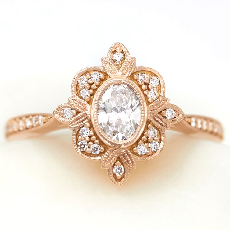 Oval diamond vintage inspired engagement ring with milgrain framing and accent diamonds