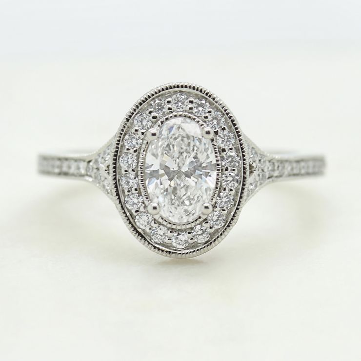 Oval diamond and a round diamond halo engagement ring with milgrain 