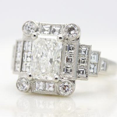 Radiant cut diamond engagement ring with milgrain framed carré cut diamond halo and accent stones