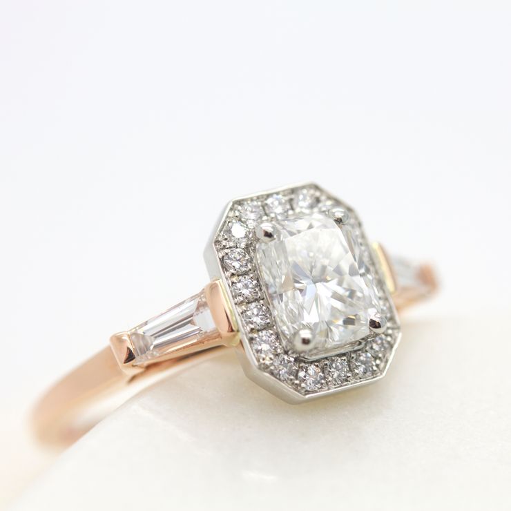 Radiant cut with diamond halo and tapered baguettes engagement ring set in platinum and rose gold