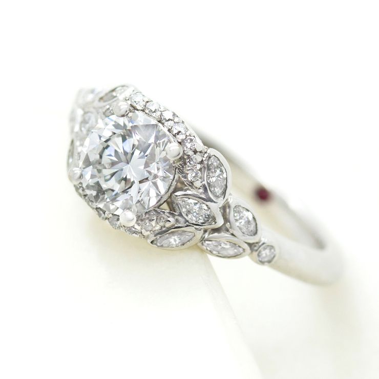Round diamond engagement ring with marquise accent stones in a leaf inspired design