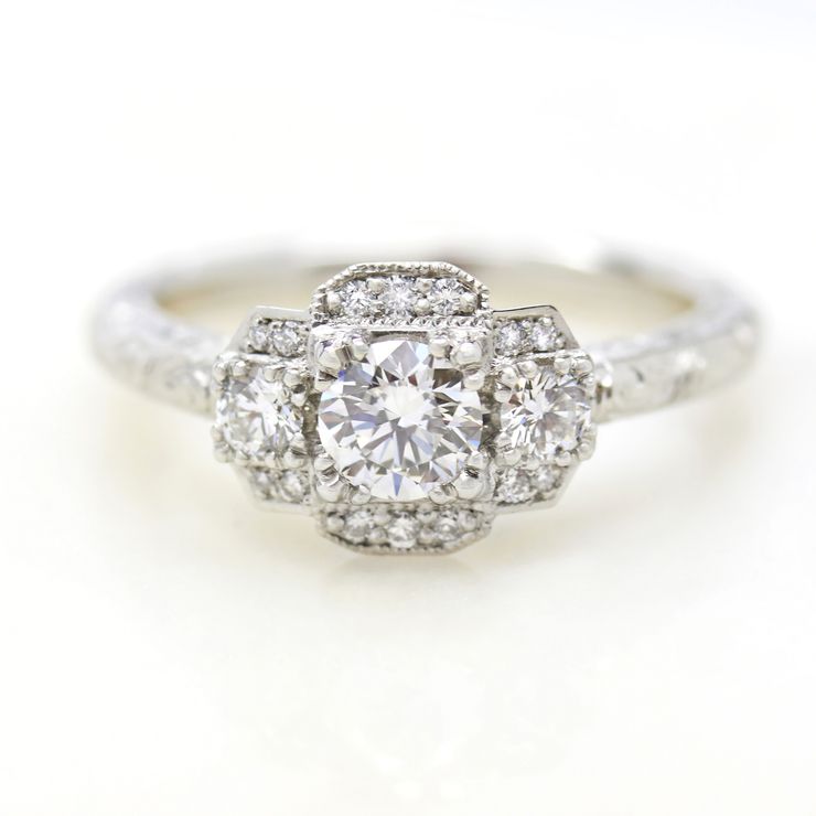 Round diamond trilogy engagement ring with bead set milgrain and hand engraving