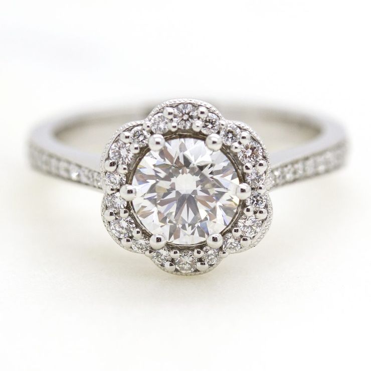 Round diamond with flower inspired halo engagement ring