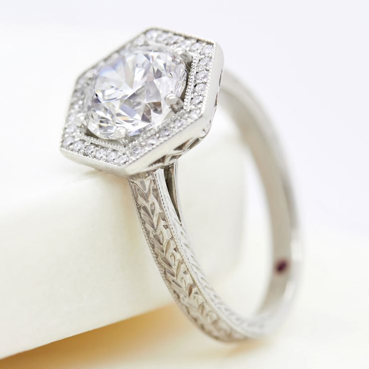 Round diamond with hexagonal diamond halo and milgrain detail