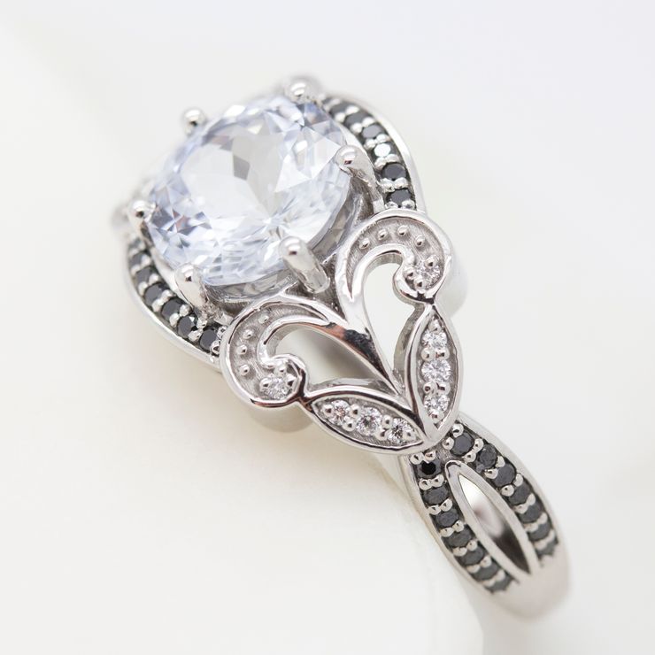 Round sapphire with bead-set black diamonds in an organic inspired engagement ring design