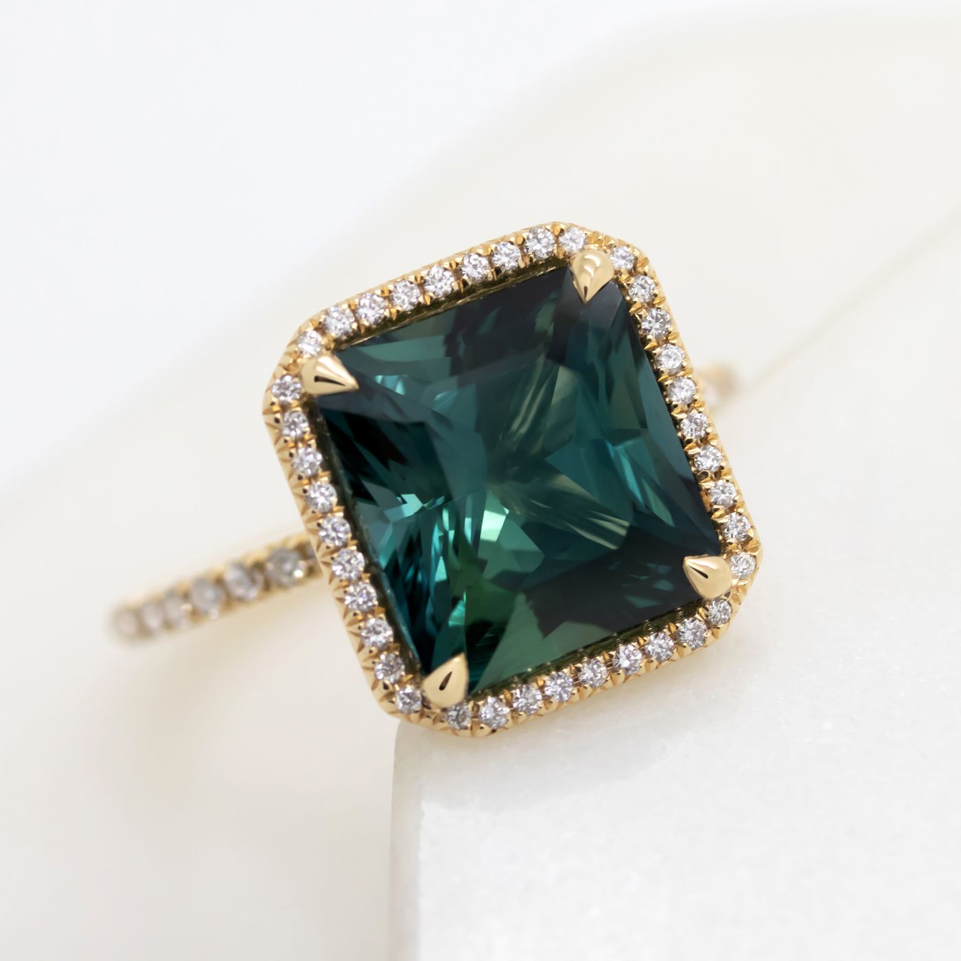 Square dark teal sapphire pave diamond halo yellow gold