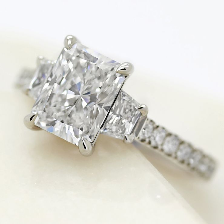 Radiant cut diamond with diamond trapezoid side stones engagement ring