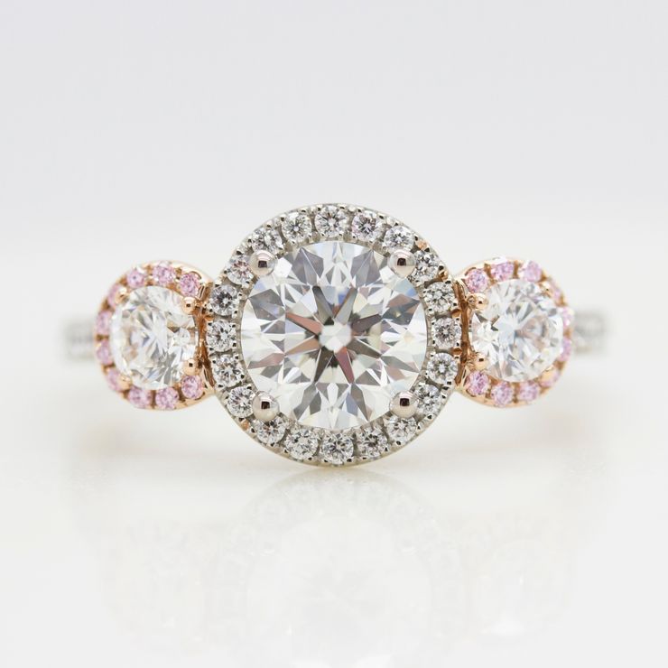 round diamond trilogy engagement ring with mixed metal and pink sapphire and diamond halo