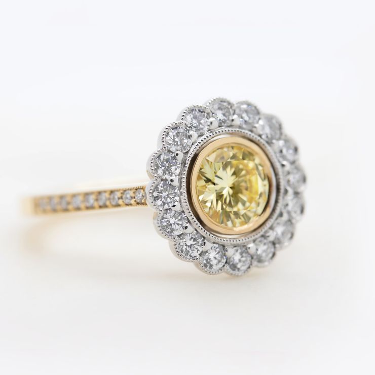 Round yellow diamond with floral round diamond halo set in a yellow gold pavé band