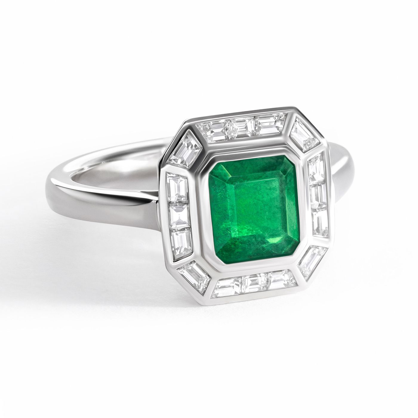 Emerald cut emerald set in platinum with a baguette halo