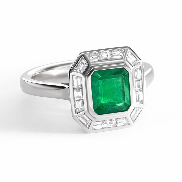 Emerald cut emerald set in platinum with a baguette halo