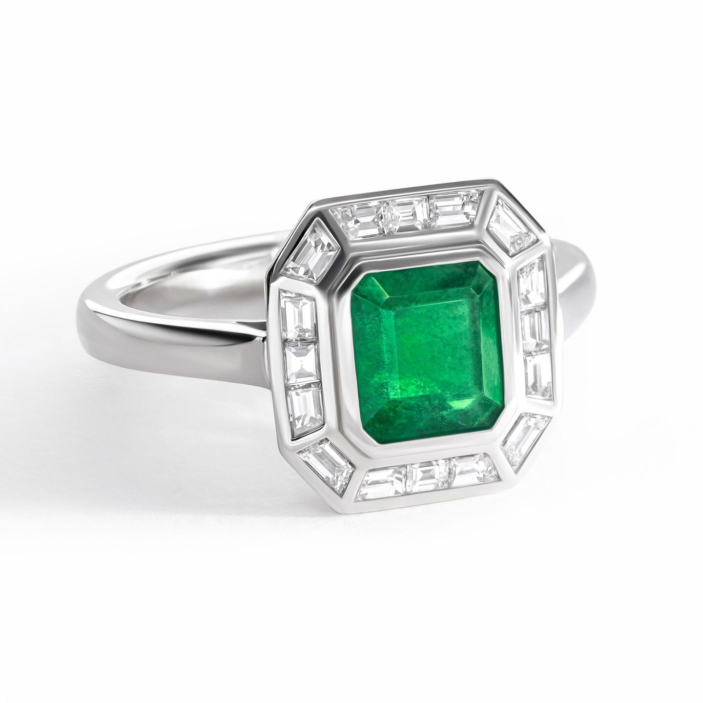 Emerald cut emerald set in platinum with a baguette halo