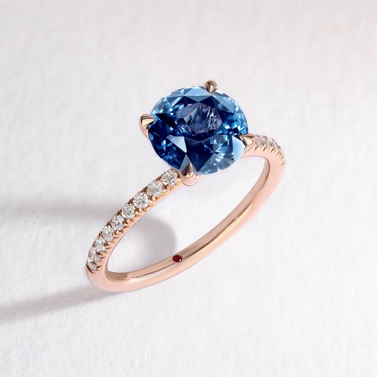 Rose gold diamond pave engagement ring with round blue sapphire centre