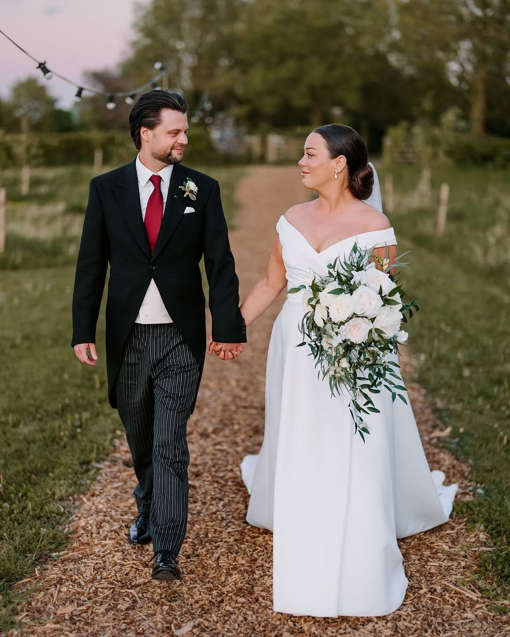 Wedding couple walking hand in hand outdoors