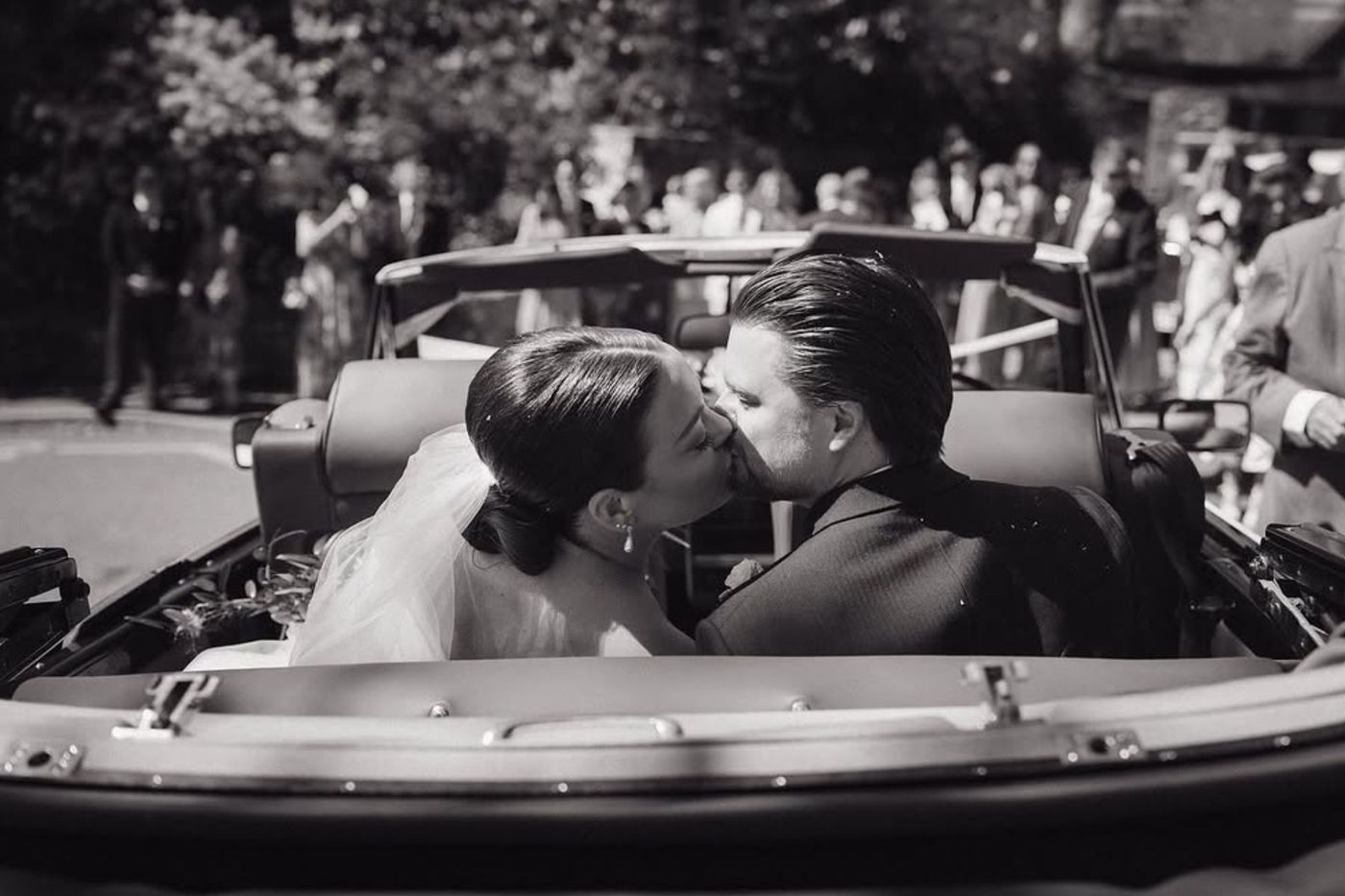 Wedding couple kissing in classic car