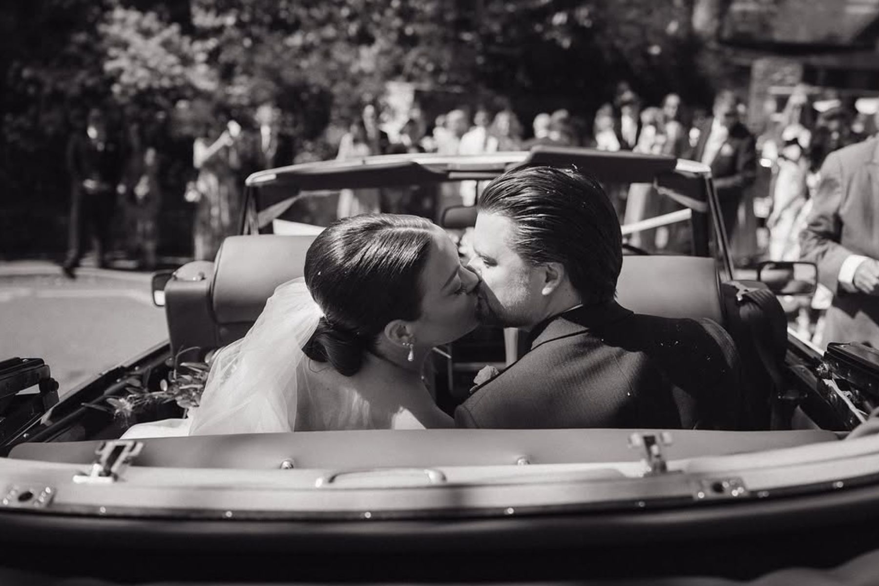 Wedding couple kissing in classic car