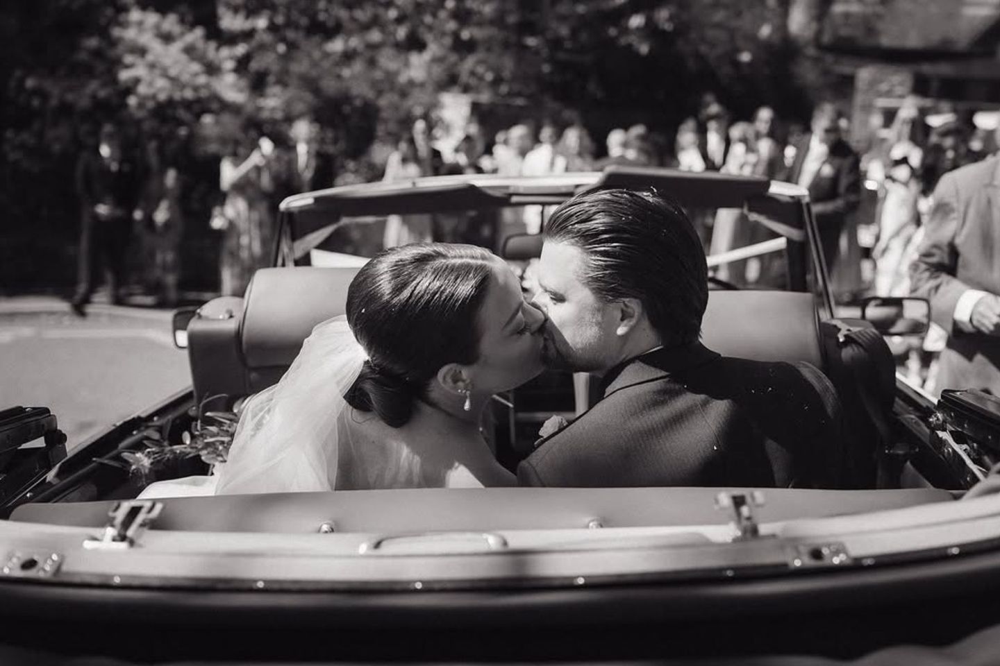 Wedding couple kissing in classic car