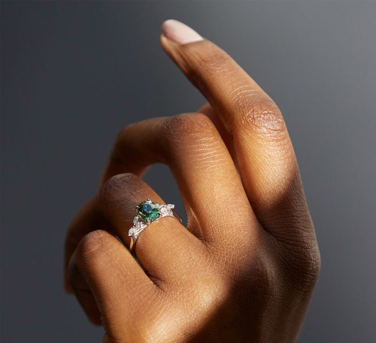 White gold engagement ring with green sapphire and diamond accents