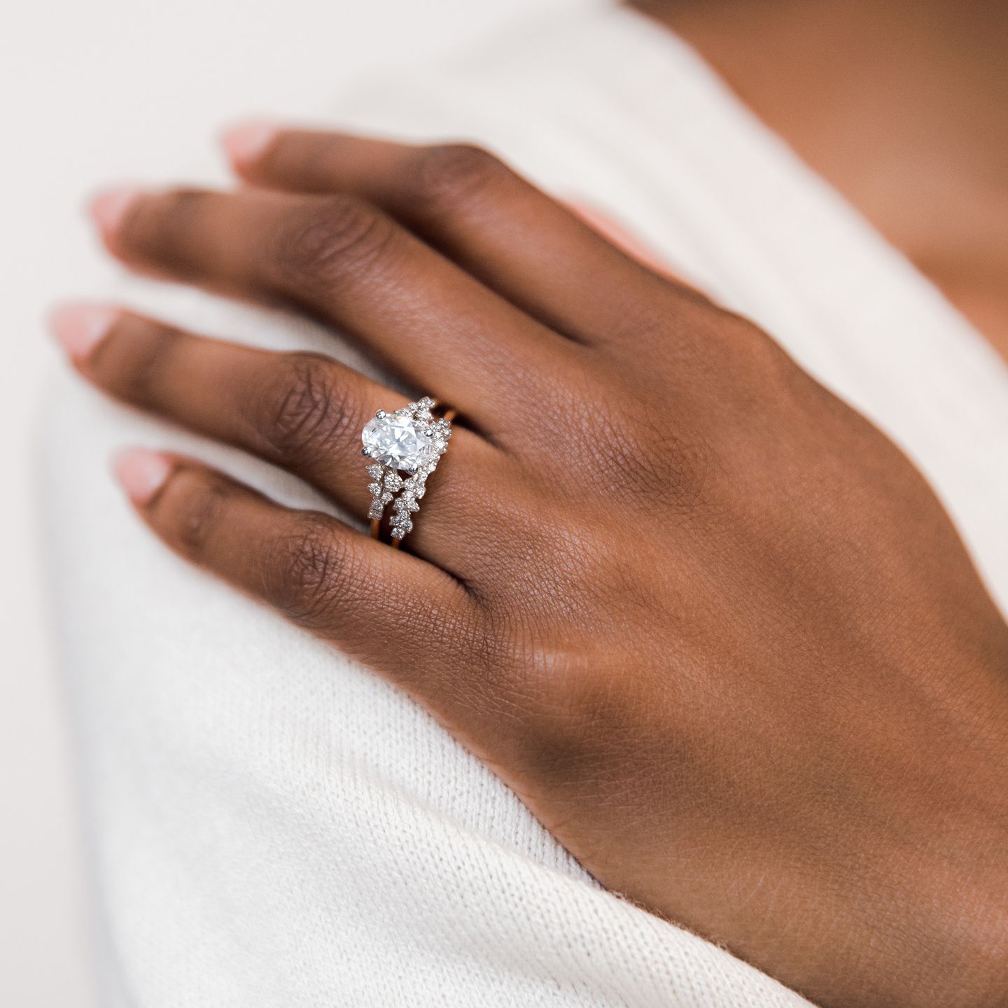 Hand wearing diamond engagement ring on natural skin tone