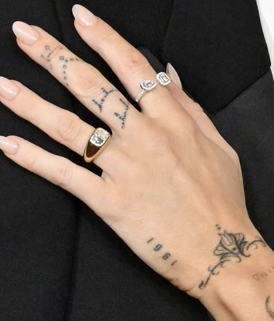 Hand with gold signet ring and diamond rings