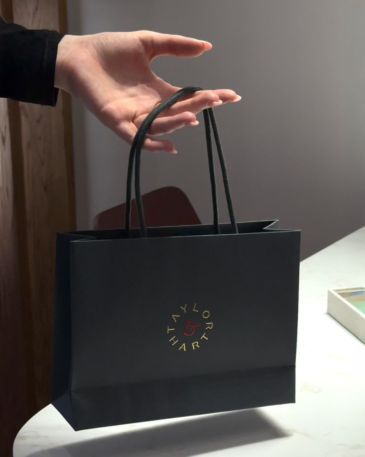 Hand holding a Taylor & Hart shopping bag
